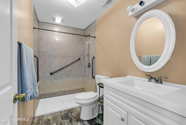 bathroom with vanity, a tile shower, and toilet