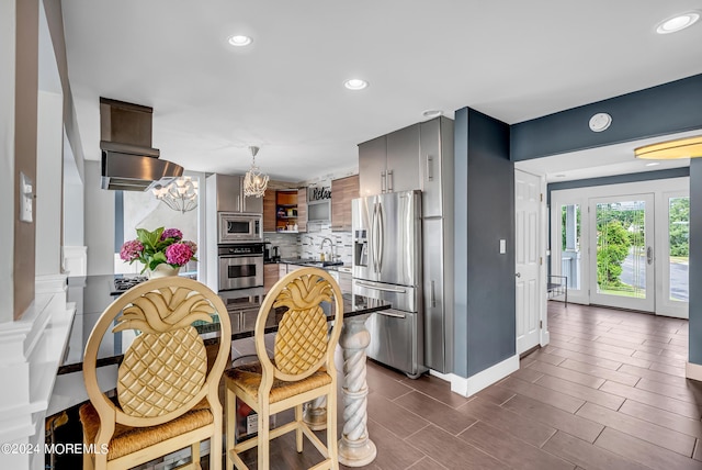 kitchen featuring appliances with stainless steel finishes, sink, decorative backsplash, and a notable chandelier