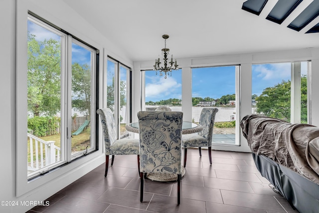 sunroom / solarium featuring an inviting chandelier