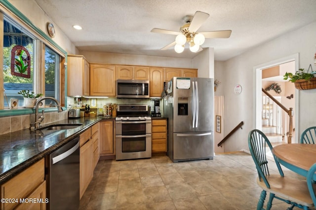 kitchen with a textured ceiling, ceiling fan, sink, and appliances with stainless steel finishes