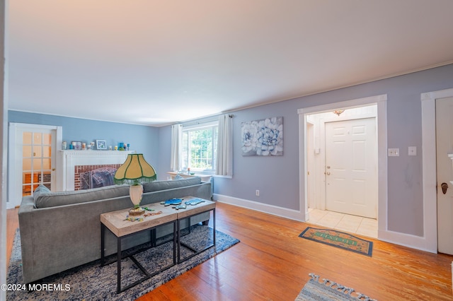 living room with wood-type flooring and a brick fireplace