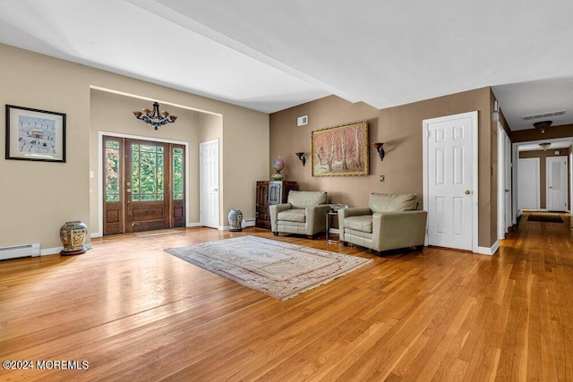 entryway with baseboard heating, a notable chandelier, and light wood-type flooring