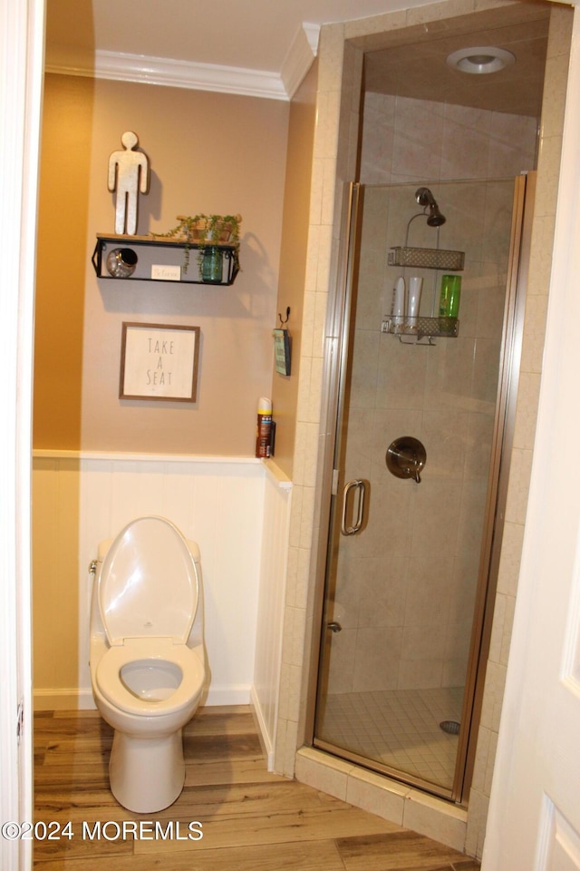 bathroom with walk in shower, wood-type flooring, crown molding, and toilet