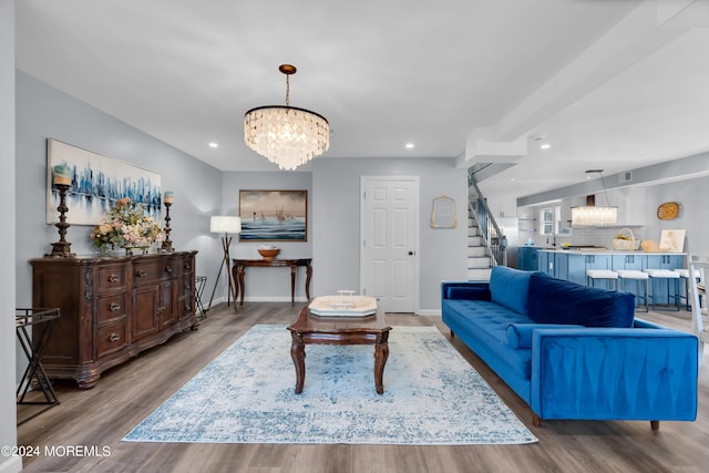 living room with sink, hardwood / wood-style floors, and a notable chandelier