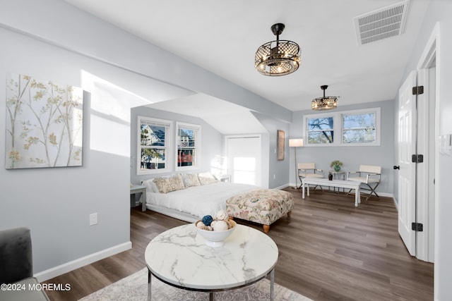 bedroom featuring an inviting chandelier and dark wood-type flooring