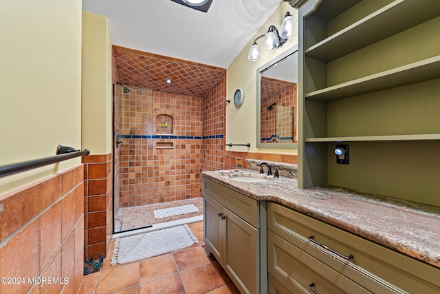 bathroom featuring tiled shower, vanity, tile walls, and tile patterned flooring