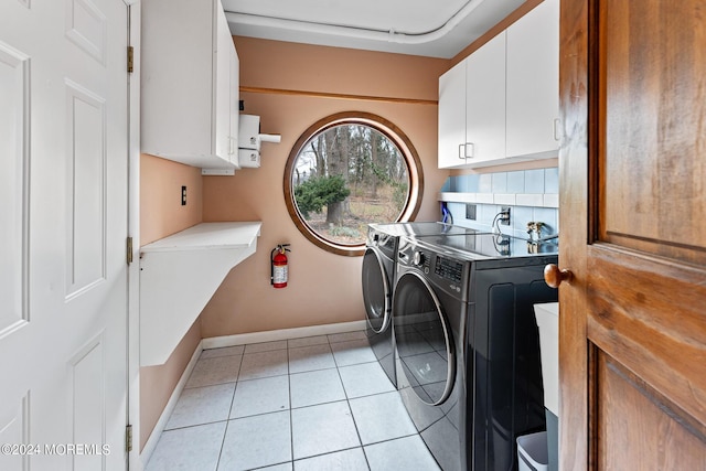 washroom with washer and clothes dryer, light tile patterned flooring, and cabinets