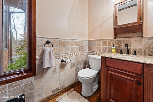 bathroom featuring vanity, toilet, and tile walls