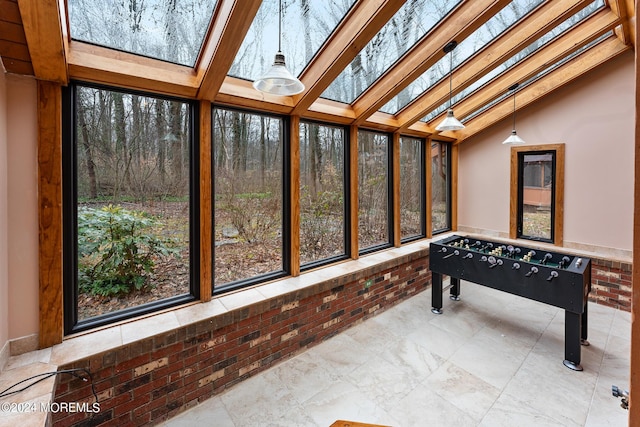 sunroom / solarium featuring vaulted ceiling with skylight and plenty of natural light