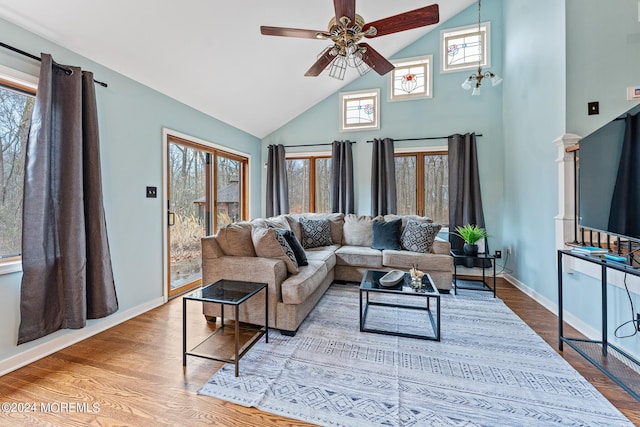 living room with ceiling fan, hardwood / wood-style floors, a healthy amount of sunlight, and lofted ceiling