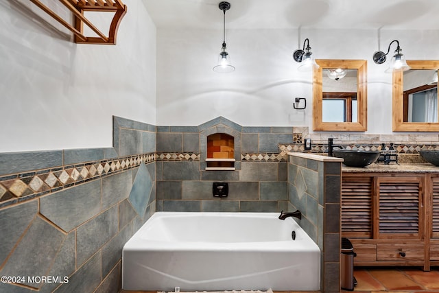 bathroom with tile patterned flooring, a bath, vanity, and tile walls