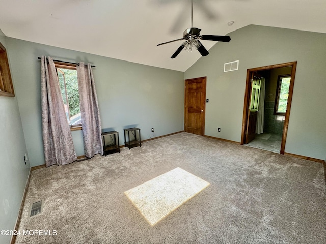 unfurnished bedroom featuring carpet flooring, ensuite bathroom, ceiling fan, and lofted ceiling