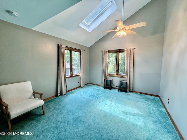 interior space featuring a skylight, ceiling fan, high vaulted ceiling, and light colored carpet