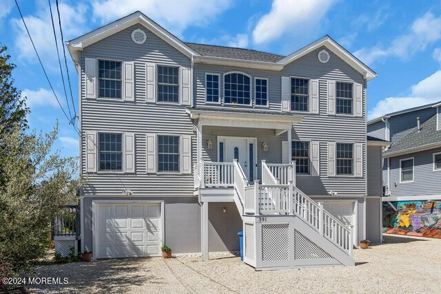 view of front of property featuring covered porch, a garage, and cooling unit