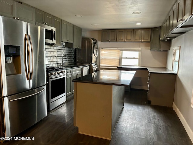 kitchen featuring plenty of natural light, a center island, stacked washer / dryer, and stainless steel appliances