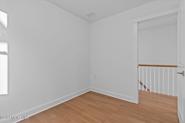 empty room with baseboards, visible vents, and light wood-style flooring