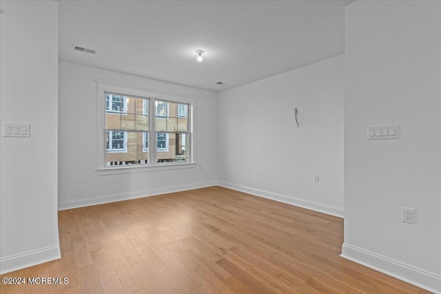 empty room with baseboards, light wood-style floors, and visible vents