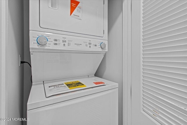 washroom with stacked washer and clothes dryer and laundry area