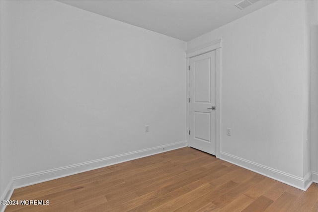 empty room featuring visible vents, baseboards, and light wood-style floors