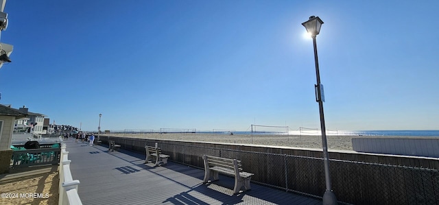 surrounding community with a water view and a beach view