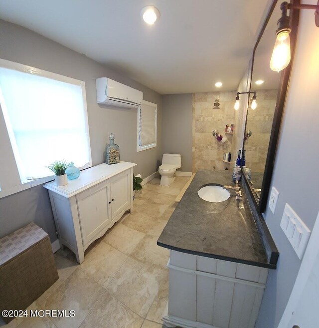 bathroom with vanity, toilet, and an AC wall unit