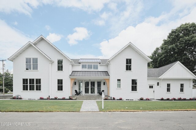 modern farmhouse style home with covered porch and a front yard