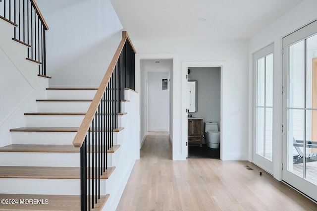 staircase featuring a healthy amount of sunlight and wood-type flooring