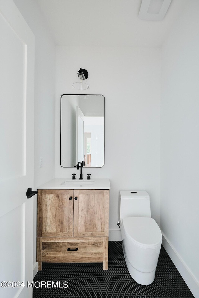 bathroom with toilet, tile patterned flooring, and vanity