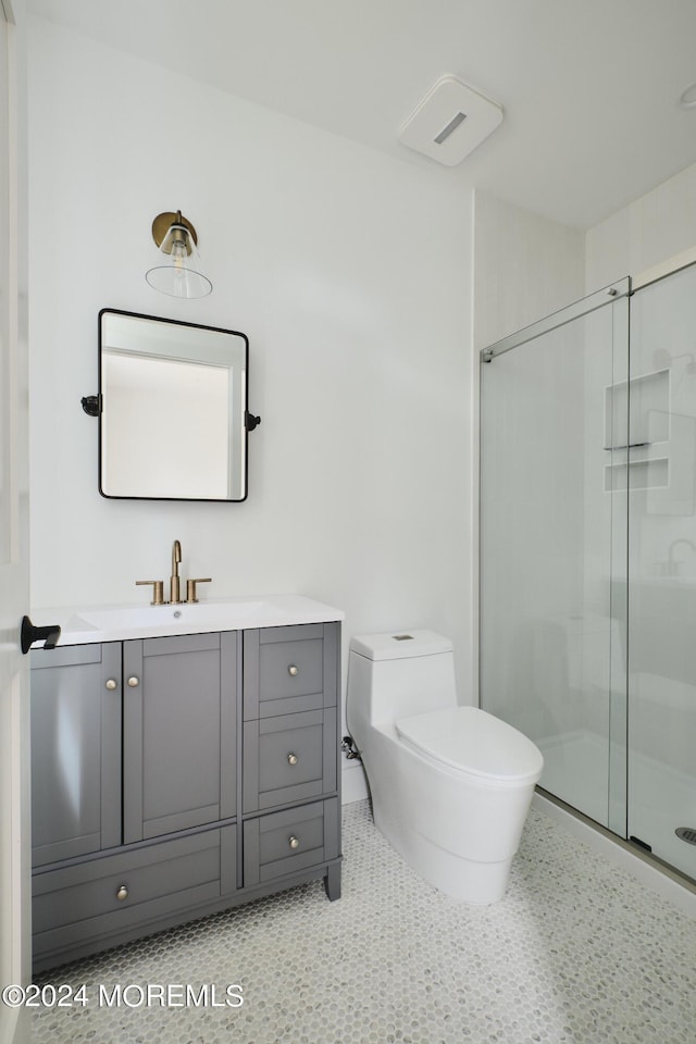 bathroom with toilet, vanity, an enclosed shower, and tile patterned floors