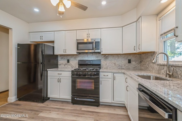 kitchen featuring black appliances, white cabinets, light wood-type flooring, and sink