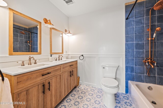 full bathroom with tiled shower / bath combo, vanity, tile patterned floors, and toilet