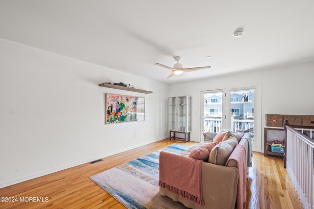 living room featuring ceiling fan and light hardwood / wood-style floors