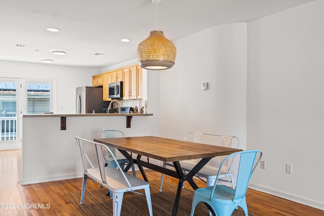 dining space with recessed lighting, baseboards, and wood finished floors