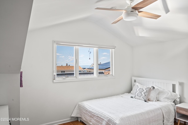 bedroom with baseboards, lofted ceiling, wood finished floors, and a ceiling fan