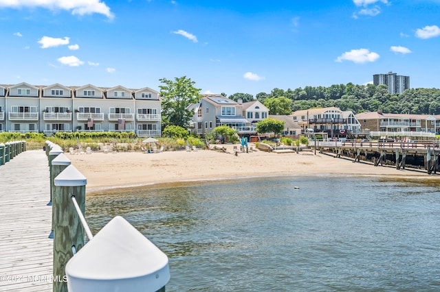 view of water feature with a residential view, a boat dock, and a view of the beach