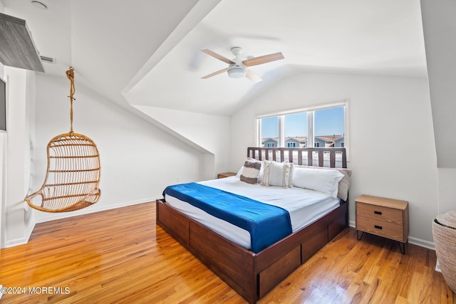 bedroom with baseboards, wood finished floors, and vaulted ceiling