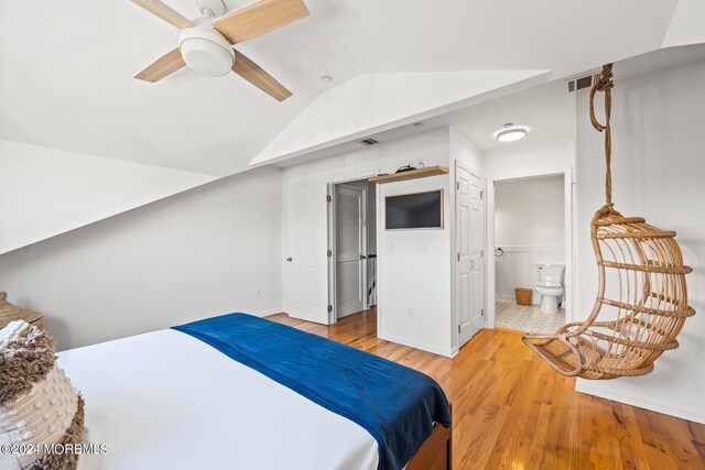 bedroom featuring lofted ceiling, connected bathroom, light hardwood / wood-style floors, and ceiling fan