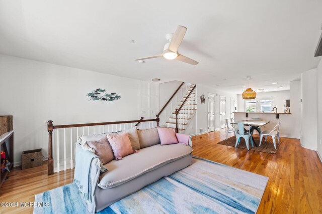 living room with ceiling fan and light hardwood / wood-style flooring