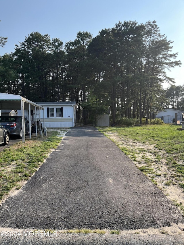 view of front of property with a carport and a shed