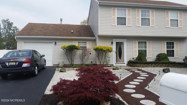 colonial inspired home featuring driveway and an attached garage