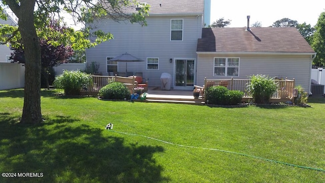 back of property featuring a yard and a deck