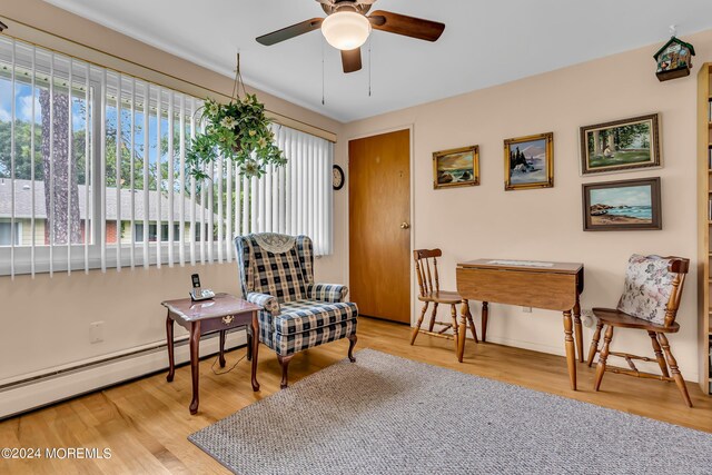 sitting room featuring a baseboard radiator, ceiling fan, and light hardwood / wood-style flooring