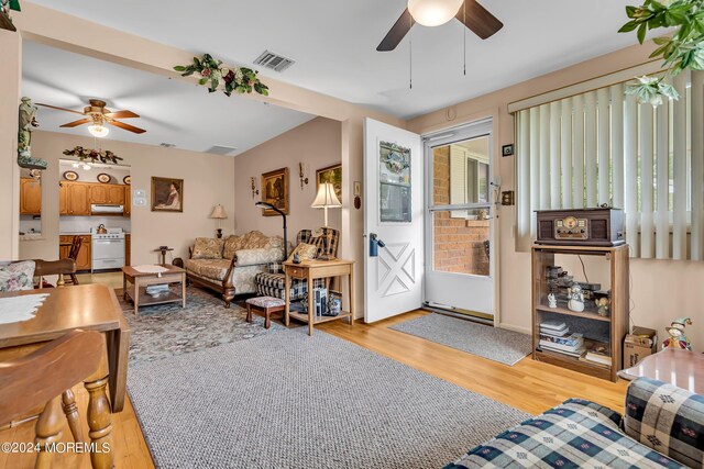 living room with ceiling fan and light hardwood / wood-style flooring