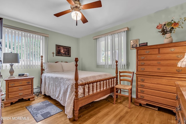 bedroom featuring ceiling fan, light wood-type flooring, and multiple windows