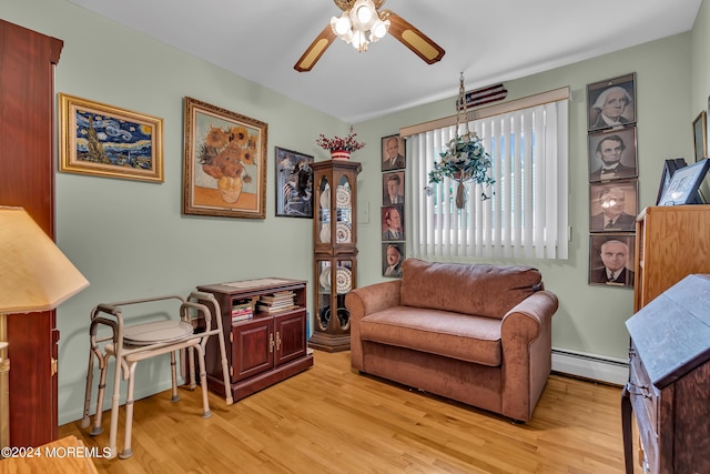 living area with light hardwood / wood-style flooring, ceiling fan, and baseboard heating