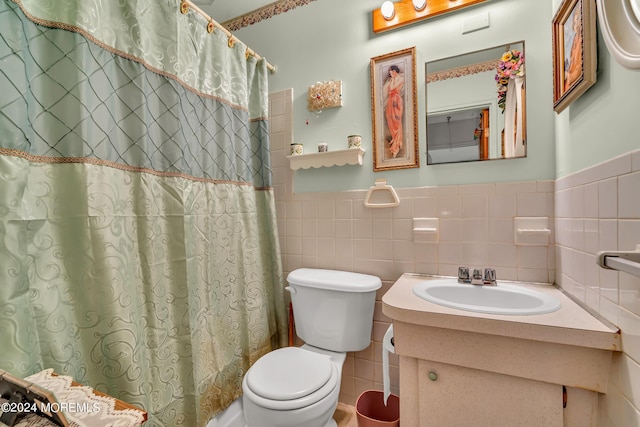 bathroom with vanity, tile walls, toilet, and walk in shower