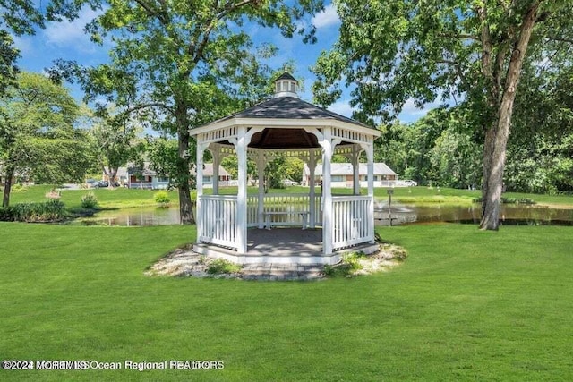 view of community featuring a yard, a water view, and a gazebo