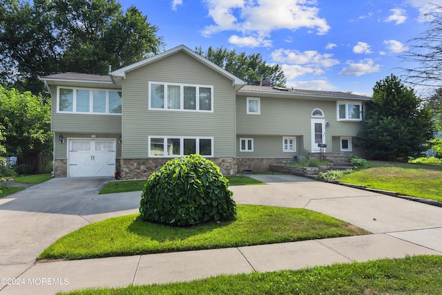 split foyer home with a garage and a front lawn