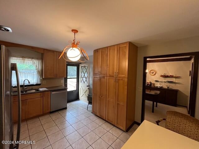 kitchen featuring sink, light tile patterned flooring, hanging light fixtures, and dishwasher