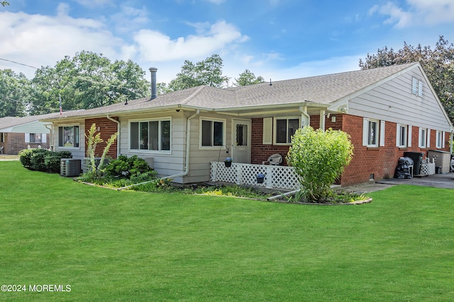 view of front of house featuring a front lawn and cooling unit